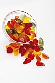 Mixed wine gums falling out of glass bowl