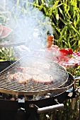 Pork steaks on smoking barbecue out of doors
