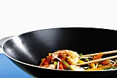 Vegetables and prawn cooked in wok with chopping sticks