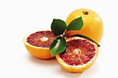 Blood oranges, whole and halved, with leaves
