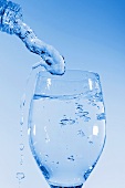 Mineralwasser in Glas einschenken