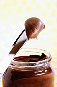 Chocolate spread in a jar with a knife, close-up