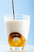 Milch mit Honig im Trinkglas
