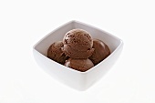 Four scoops of chocolate ice cream in a dish