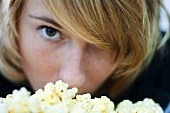 Young woman eating popcorn, close-up