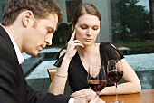 Couple drinking red wine looking unhappy