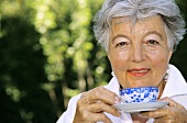 Senior woman holding cup of tea, close-up