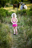 Girl watching cows in pasture