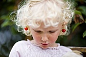 Girl with pair of cherries over her ears