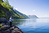 Mann angelt im Gratangen-Fjord, Norwegen