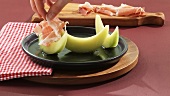Arranging melon and Parma ham on a plate