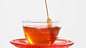 Stirring a cup of tea with a sugar swizzle stick