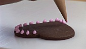 Herzförmiges Schokoladengebäck verzieren