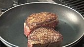 Frying fillet steaks in a frying pan