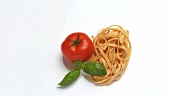 Tagliatelle with tomato and basil leaves