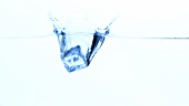 Ice cube falling into water
