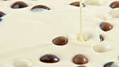 Geschmolzene weiße Schokolade mit Schokokugeln