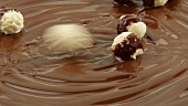 weiße Schokokugeln auf geschmolzener Milchschokolade