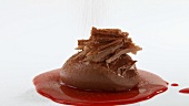 Mousse au chocolat with chocolate curls and berry sauce