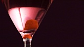 A glass of Cosmopolitan with orange peel