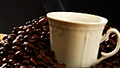 Sack mit Kaffeebohnen und dampfender Kaffeetasse