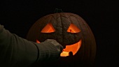 Lighting a tealight in a Halloween pumpkin