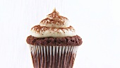 Chocolate muffin with cream topping and cocoa powder