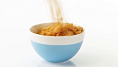Putting cornflakes into a bowl