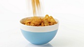 Putting cornflakes into a bowl