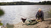 Mann bereitet den frisch gefangenen Fisch zum Grillen vor