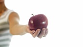 Junge Frau hält einen roten Apfel