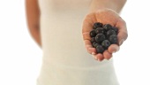 Young woman holding fresh blueberries