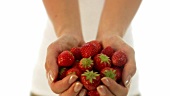 Junge Frau hält frische Erdbeeren