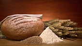 Frisch gebackenes Brot, Getreideähren, Mehl & Getreidekörner