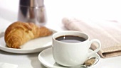 Eine Tasse Kaffee mit Croissant