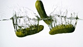 Three cucumbers falling into water