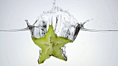 A slice of carambola falling into water