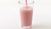 Pouring strawberry milk into a glass
