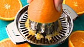 Squeezing an orange on a citrus squeezer