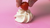 Putting a strawberry on a cream rosette