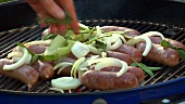 Sausages with onions and herbs on a barbecue