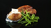 Fried T-bone steak with green beans and baked potato