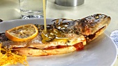 Pouring melted butter over stuffed trout