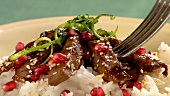 Beef with rice, pomegranate seeds and sesame seeds
