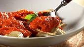 Plating mushroom ravioli with tomato sauce