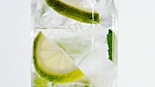 Ein Glas Mineralwasser mit Minzblättern und Limettenscheiben