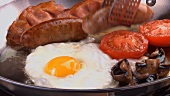 Englisches Frühstück mit Bratwurst & Spiegelei in der Pfanne