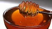 A bowl of honey with honey dipper