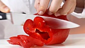 Eine rote Paprika in Ringe schneiden