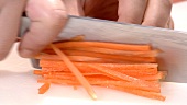 Cutting a carrot into sticks (close-up)